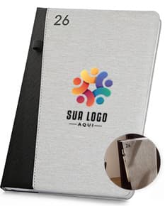 Agenda 2026 com suporte para esferográfica em fundo branco.