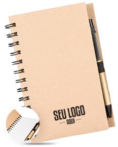 Caderno Ecológico com capa de papel kraft marrom, fecho de elástico e detalhe de folha verde. Páginas internas em papel reciclado.